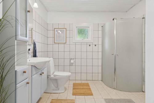 a white bathroom with a toilet and a shower at Spacious, Lovely Cottage In North Zealand in Melby