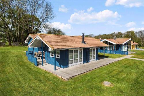 a blue house with a deck in a field at Beach, Starry Sky And Peace By The Water in Augustenborg