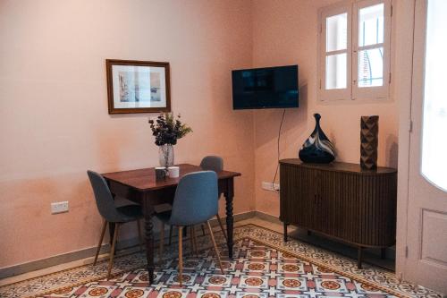 スリーマにあるNEW Apartment in Sliema by People & Placesのテーブルと椅子とテレビのあるダイニングルーム