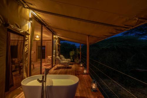 a bathroom with a tub on a deck at Olkupelia Mara in Talek