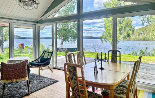 a dining room with a table and chairs and a view of the water at 2 Bedroom Cozy Home In Sandöverken in Sandöverken