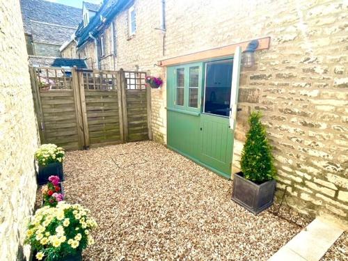 a green door on the side of a building at Cozy Cotswold Burford Cottage in Burford