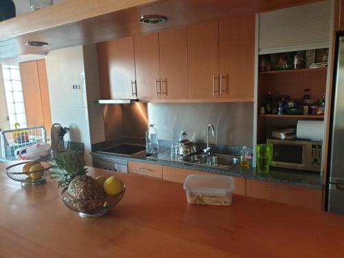 a kitchen with a table with a bowl of fruit on it at Beach Apartment Furadouro in Ovar