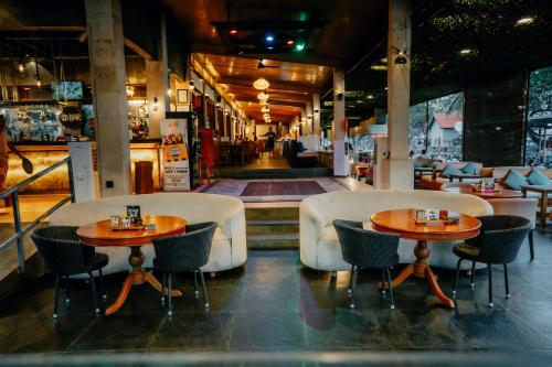 a restaurant with two tables and chairs and a hallway at Grand Istana Rama Hotel in Kuta