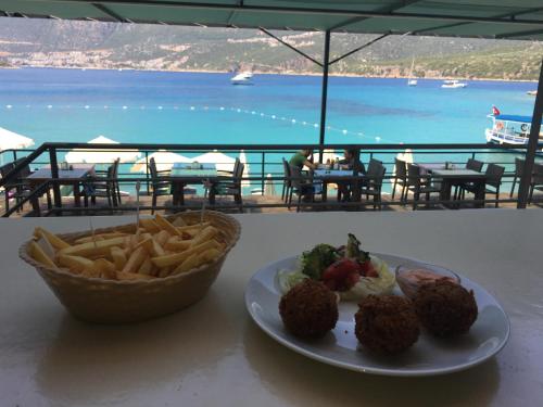 a table with a plate of food and a bowl of fries at La Moda Beach Hotel in Kaş