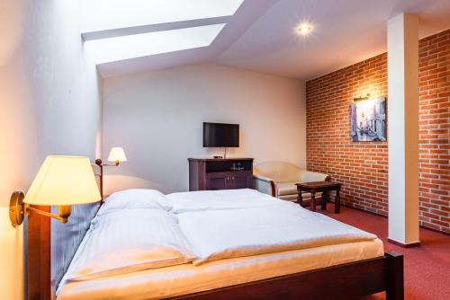 Una cama o camas en una habitación de Wellness Hotel Gondola