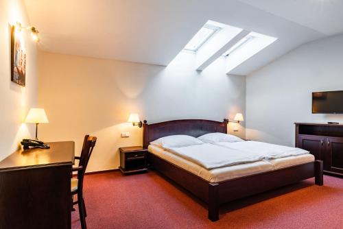 Una cama o camas en una habitación de Wellness Hotel Gondola
