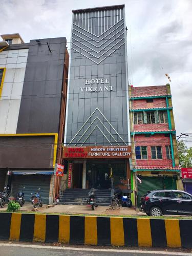 een gebouw met een uithangbord aan de zijkant bij Hotel Vikrant in Deoghar
