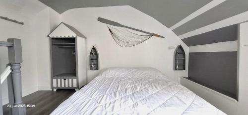 - une chambre avec un lit avec un filet sur le mur dans l'établissement Cap en vue, à Fécamp