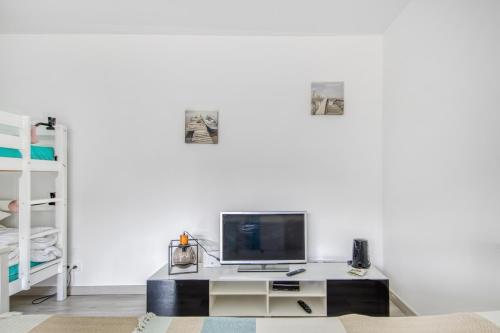 a living room with a tv and a desk at Studio Judicaelle in Lège-Cap-Ferret