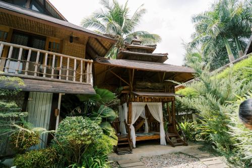 a house with a balcony on the side of it at Sitio Maupot Family Resort in Sampong