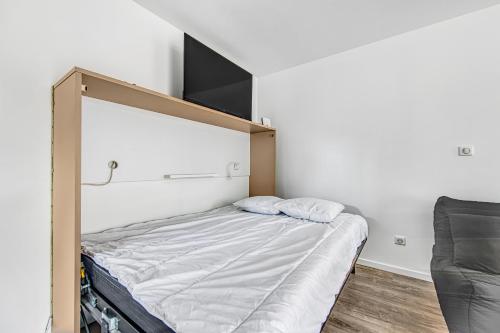 a bed in a room with a large headboard at Studio Abygaelle in Lège-Cap-Ferret