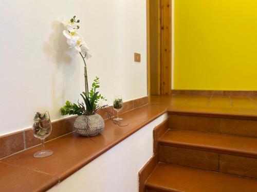 a room with stairs with a vase of flowers and glasses at Orchidea Retreat - View of Mountains & Vines in San Demetrio neʼ Vestini