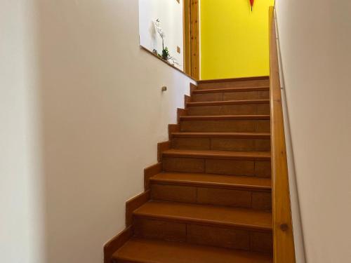 a staircase with wooden steps and a yellow wall at Orchidea Retreat - View of Mountains & Vines in San Demetrio neʼ Vestini