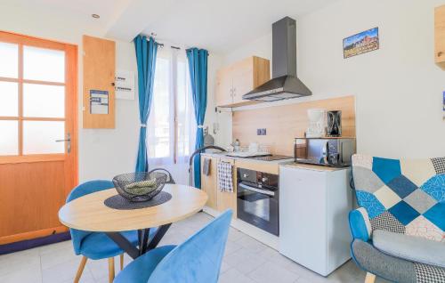 a kitchen with a table and blue chairs in a room at Jolie Maison Proche Plage in Le Crotoy