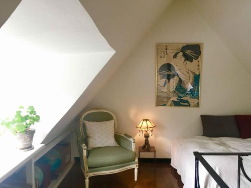 a attic bedroom with a bed and a chair at Old Guardhouse On West Møn in Askeby