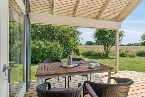 a patio with a table and chairs on a porch at Cosy Cottage With Open View Of The Meadow in Store Fuglede