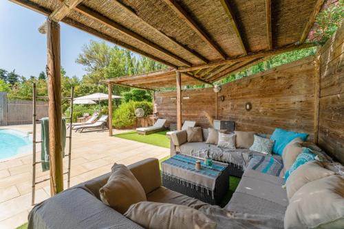 - un salon avec des canapés et une piscine dans l'établissement Tonneau Prestige, à Jonquières