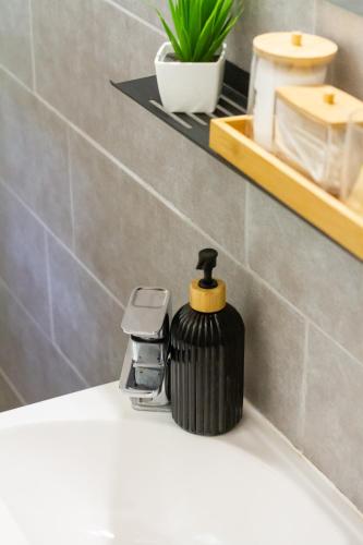 a black soap dispenser sitting on top of a sink at Hilltop Wellness Haven W AC & Jacuzzi by NW in Recsk