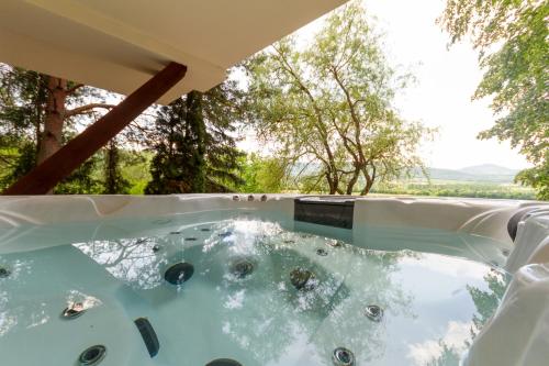 a jacuzzi tub in the backyard of a house at Hilltop Wellness Haven W AC & Jacuzzi by NW in Recsk