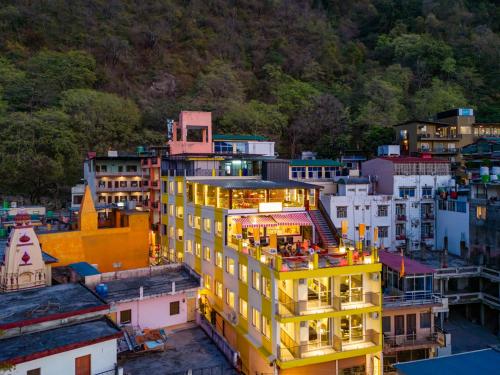 a yellow building with lights on top of a city at The Hosteller Rishikesh, Ganges in Rishīkesh