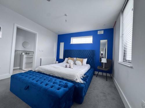a blue bedroom with a large bed with a blue couch at Hot Tub Luxe Villa In The Heart Of Dublin in Dublin