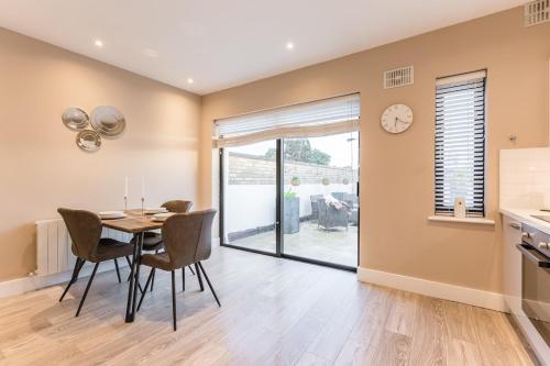 a dining room with a table and chairs and a clock at Hot Tub Luxe Villa In The Heart Of Dublin in Dublin