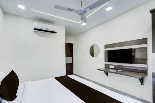 a bedroom with a bed and a flat screen tv at Hotel O Vijaya Grand in Pedda Ambarpet