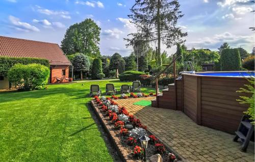 a backyard with chairs and a swimming pool at Awesome Home In Cieciorka in Cieciorka