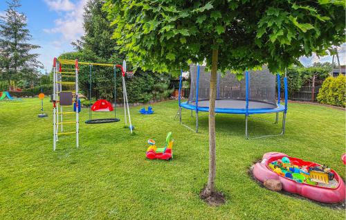 a park with a playground with a tree and swings at Awesome Home In Cieciorka in Cieciorka