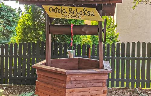 a wooden bird feeder in front of a fence at Awesome Home In Cieciorka in Cieciorka