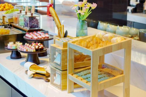 um bufê com pães e doces sobre uma mesa em Atour Hotel Qingdao Laoshan Shilaoren Beach em Qingdao