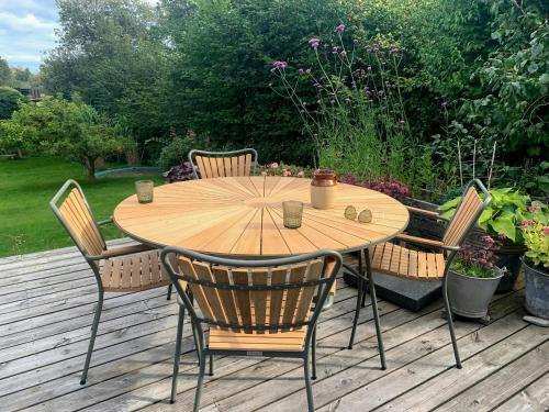 a wooden table and chairs on a wooden deck at Home With View In Rågeleje in Vejby