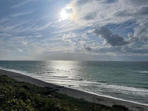 a view of a beach with the ocean and a cloudy sky at Home With View In Rågeleje in Vejby