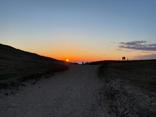 a dirt road with the sunset in the background at Home With View In Rågeleje in Vejby