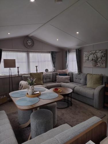 a living room with a couch and a table at Seton Sands Holiday Village Luxury 61 Muirfield Near Edinburgh Free WiFi in Port Seton