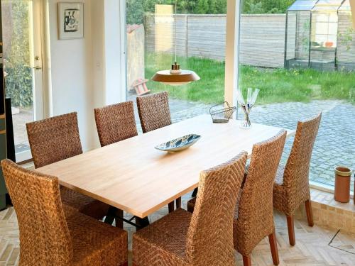 a dining room table and chairs with a wooden table and a table at Historic Laundry House By Gentofte Lake in Gentofte