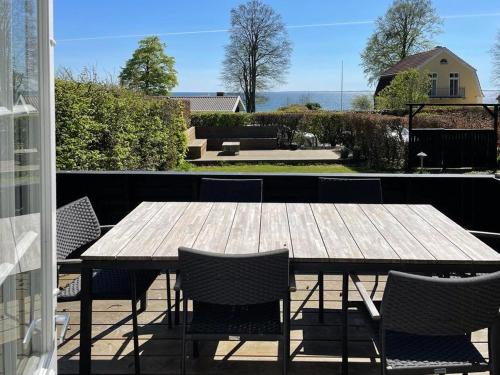 a wooden table and chairs on a patio at Thatched Wooden House With Sea View in Haderslev