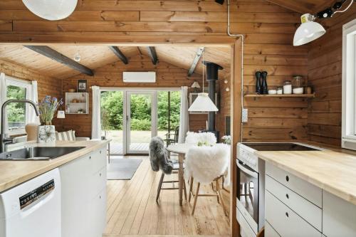 a kitchen with wooden walls and a table and chairs at Simple Life In Traditional Home By Lyngså Beach in Sæby