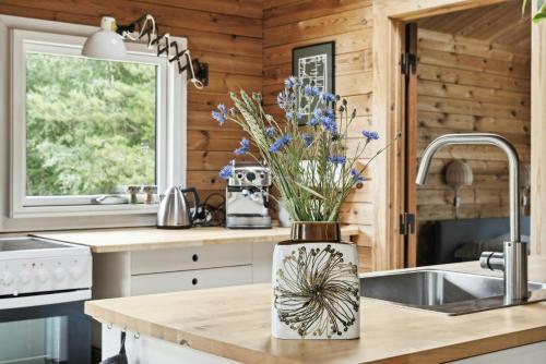 a kitchen with a sink and a vase with blue flowers at Simple Life In Traditional Home By Lyngså Beach in Sæby