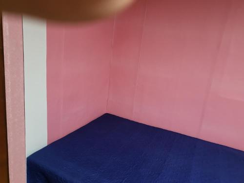 a small room with a blue bed in it at 오색약수온천모텔 Osaek Hot Spring Motel in Yangyang