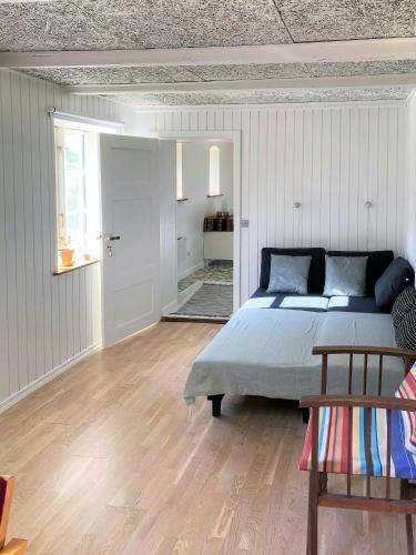 a bedroom with a large bed and a wooden floor at Peaceful Holiday Apartment By Skærbæk Plantation in Them