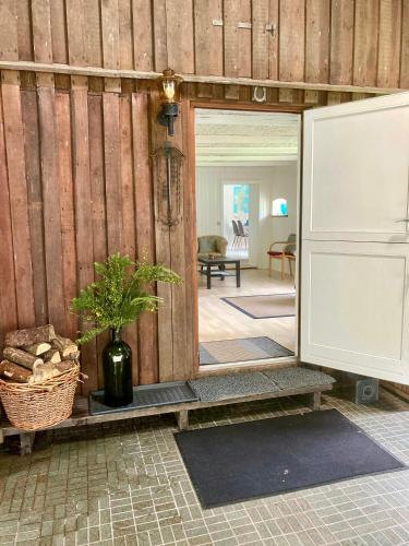 a room with a wooden wall with a door and a plant at Peaceful Holiday Apartment By Skærbæk Plantation in Them