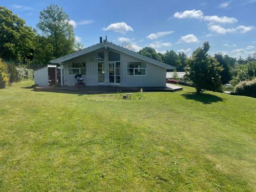 a small house on a lawn with a dog in the yard at Family Retreat By Roskilde Fjord in Ølsted