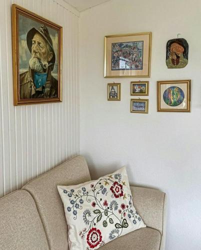 a living room with a couch and a painting of a man at Retro Cottage With Fjord View in Storvorde