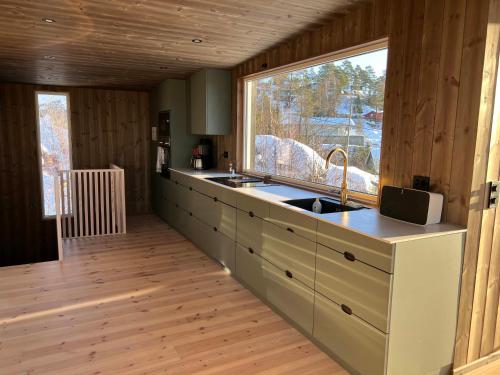 a kitchen with a sink and a large window at Traditional Cabin In Modern Drøbak in Drøbak