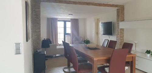 a dining room with a wooden table and chairs at Ferienwohnung Weitblick in Wadgassen