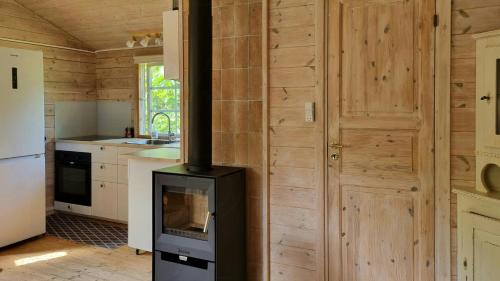 a kitchen with a stove in the middle of a room at Blue Cottage On Idyllic Askø in Maribo