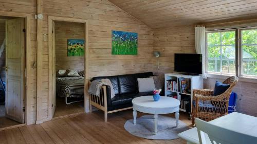 a living room with a couch and a tv at Blue Cottage On Idyllic Askø in Maribo
