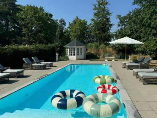 una piscina con due campi da pallavolo e sedie a sdraio di Historic Beach Villa With Pool At Marielyst a Bøtø By